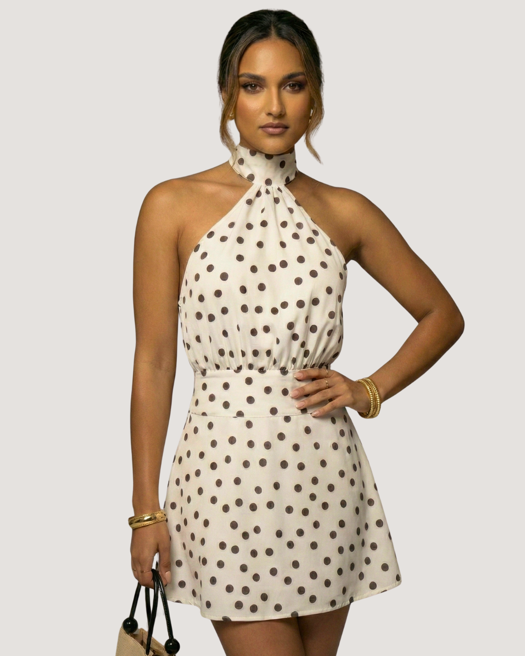 Woman wearing a polka dot dress against a plain background
